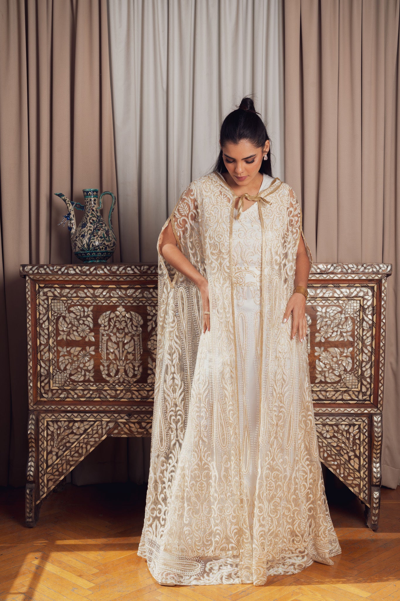 An elegant white and gold embroidered kaftan with a hood