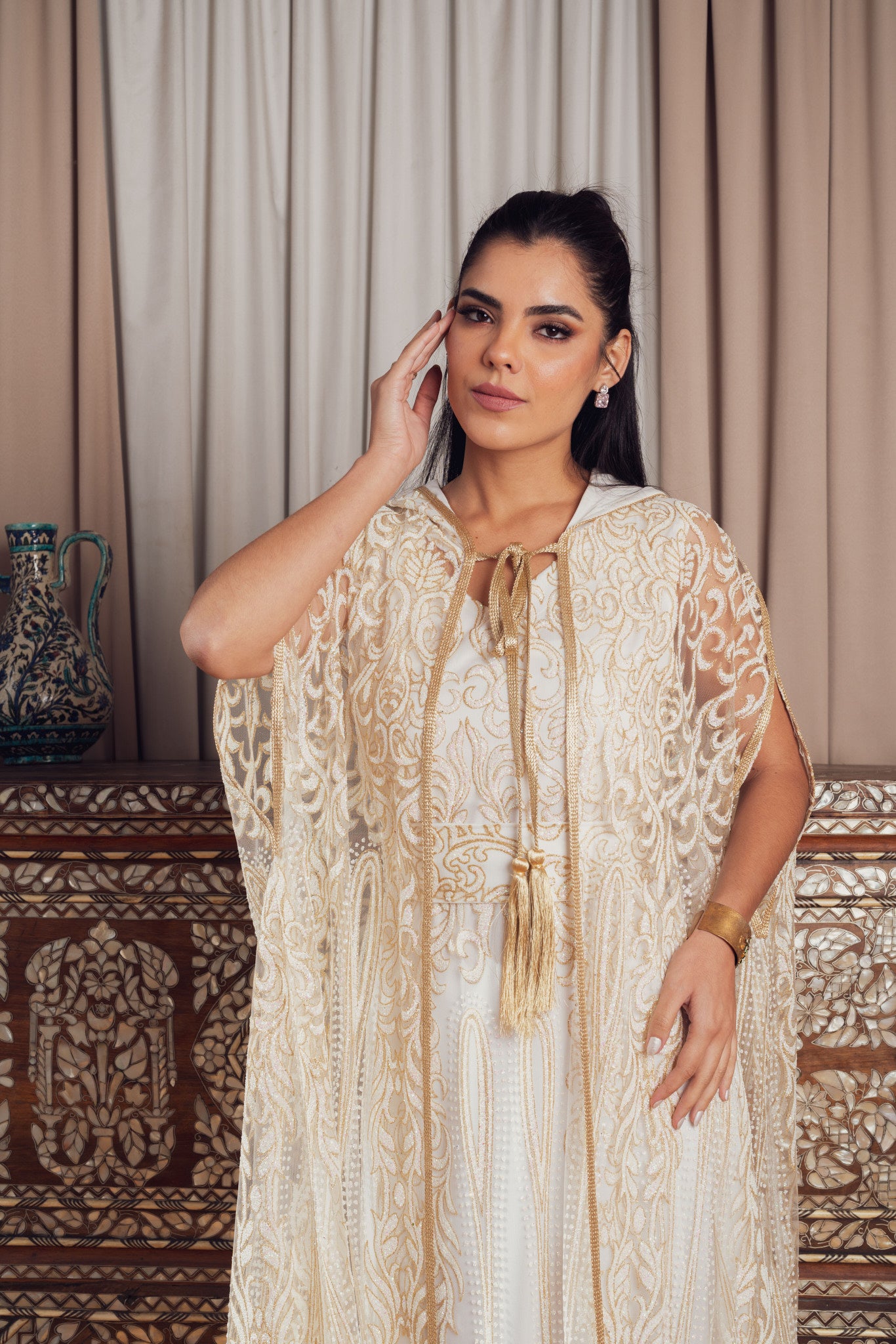 An elegant white and gold embroidered kaftan with a hood