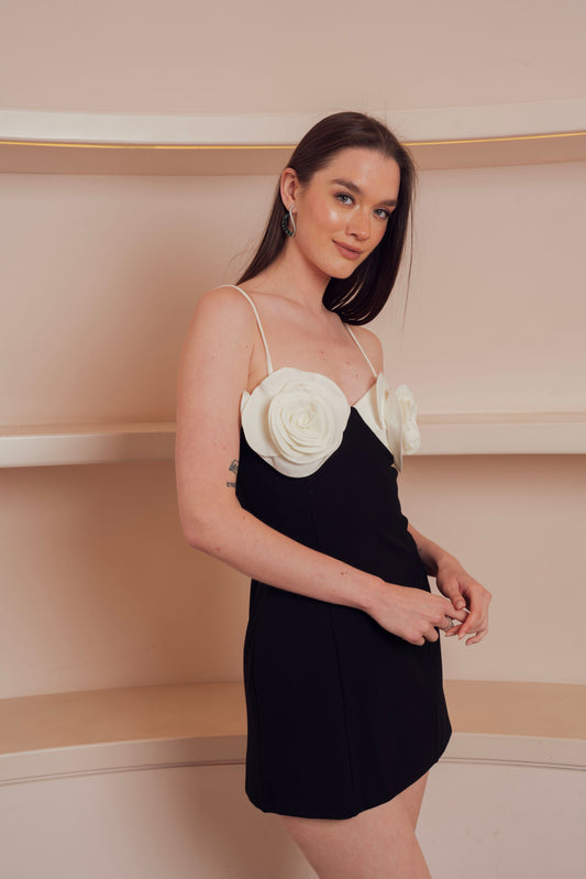 Black mini dress with floral detail on the chest.