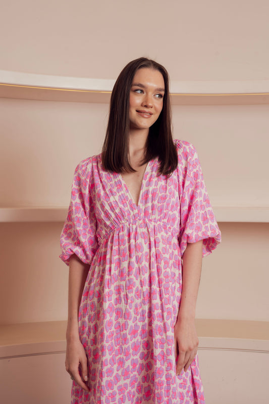 Pink printed midi dress with puff sleeves and a deep V-neckline.