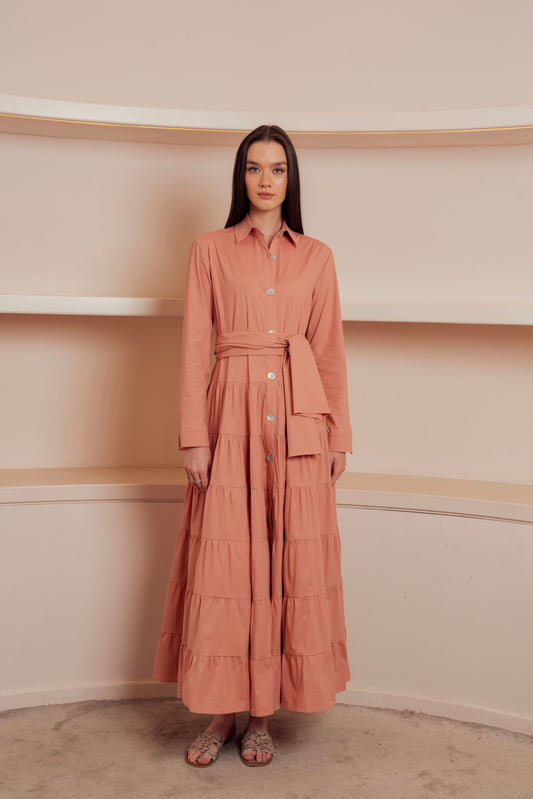Tiered shirt dress in peach with waist tie and button-down front.