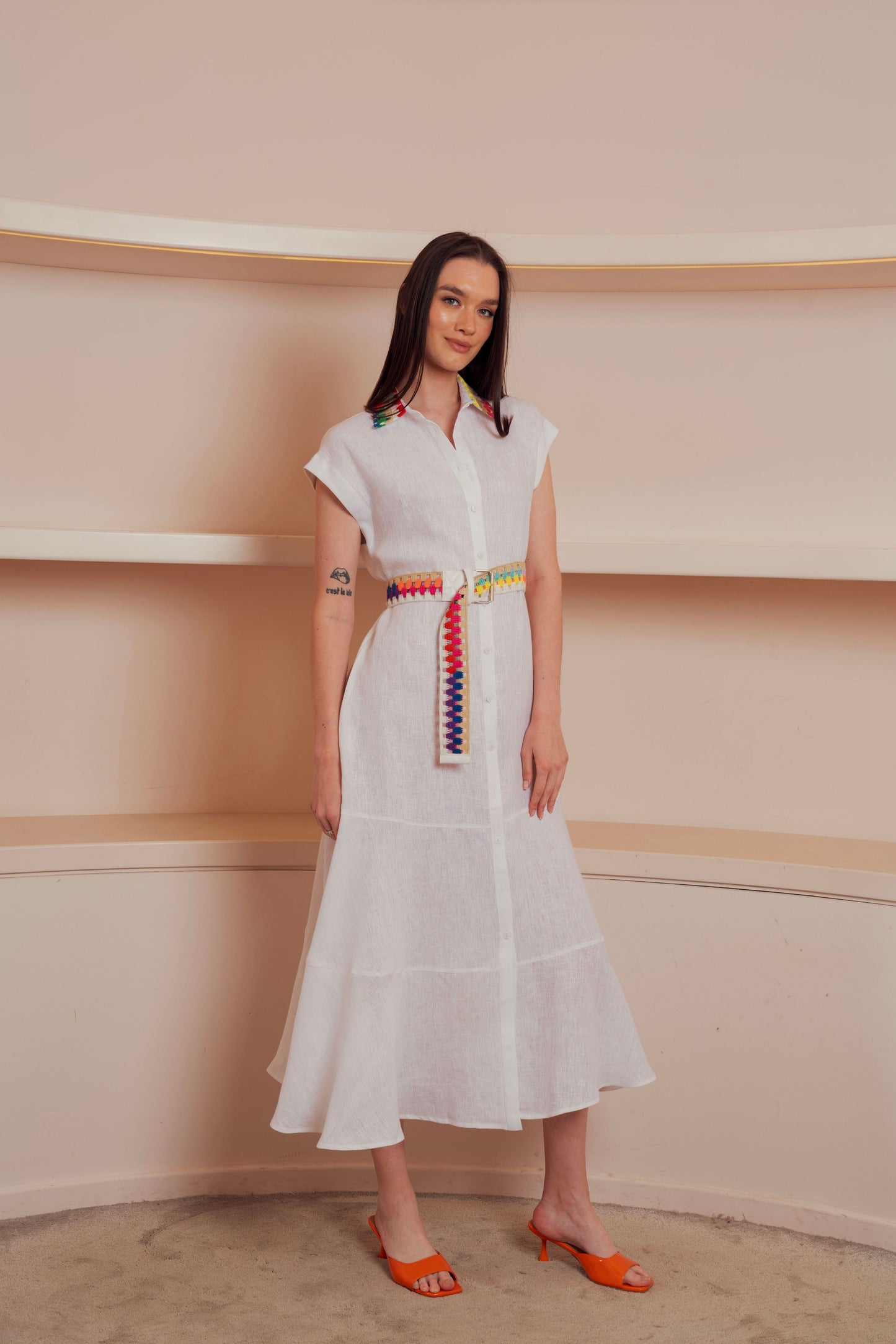 White button-down midi dress with colorful embroidered belt and collar accents.